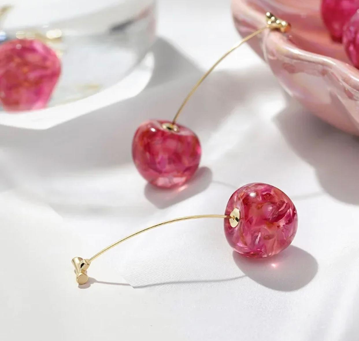 Stylish fiery pink acrylic cherry earrings in a long drop design