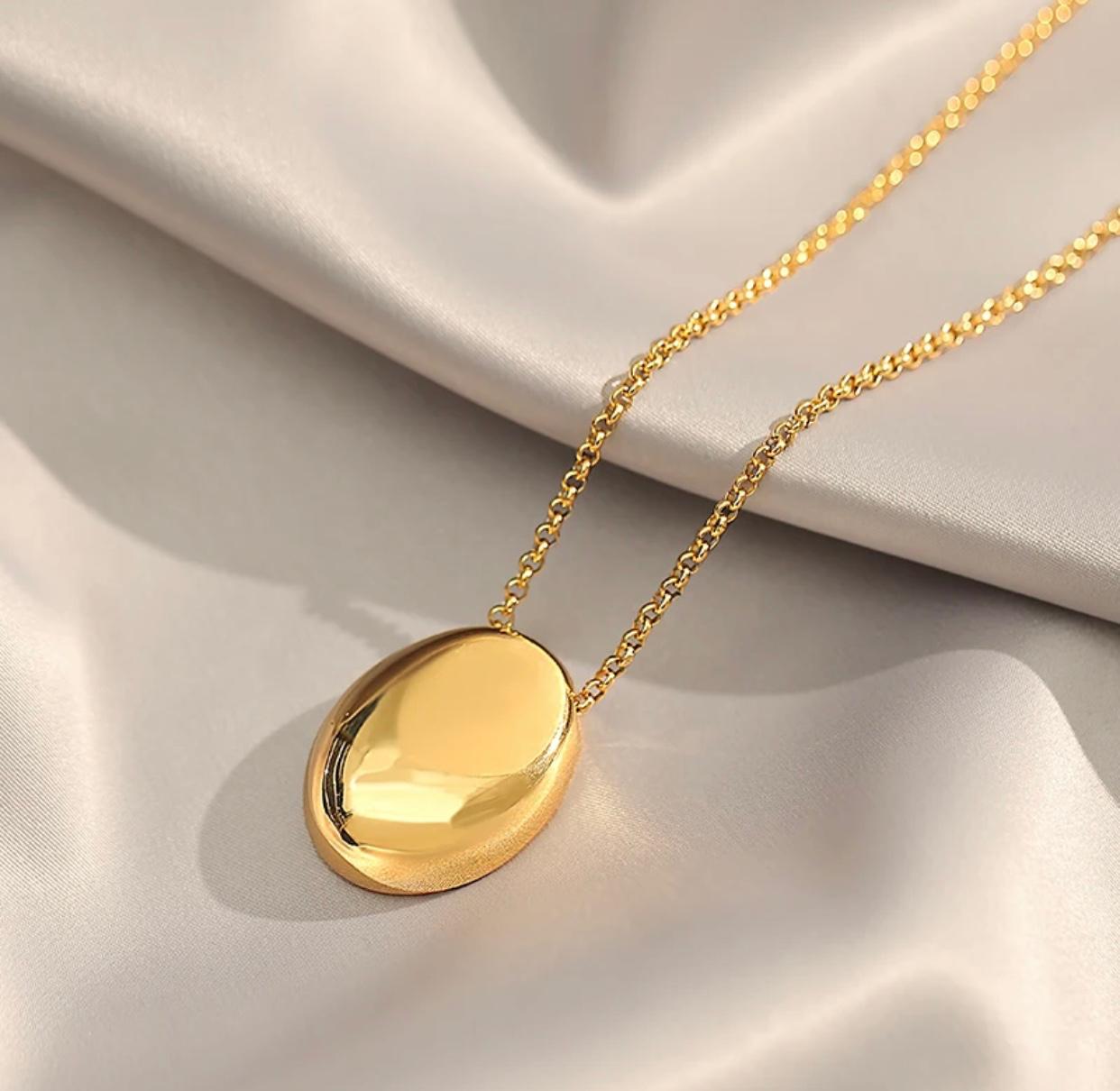 An oval shaped pendant necklace made of stainless steel