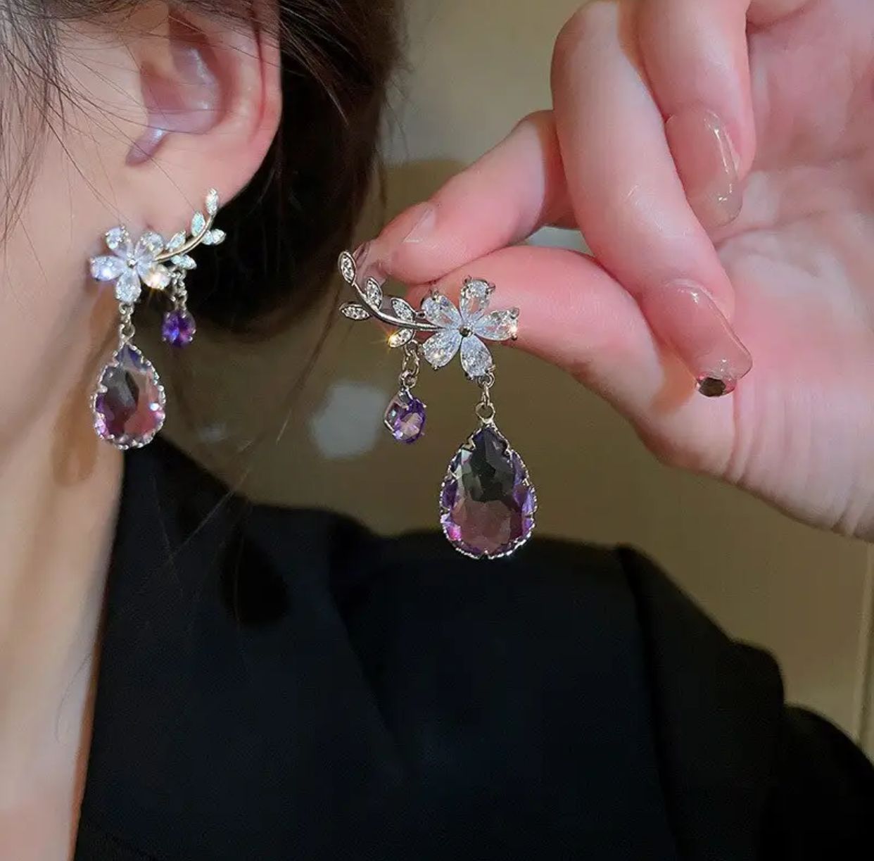 A pair of water drop earrings featuring purple zircon stones