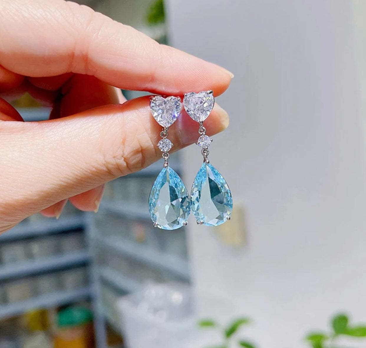 Silver hoop earrings featuring sky blue cubic zirconia stones